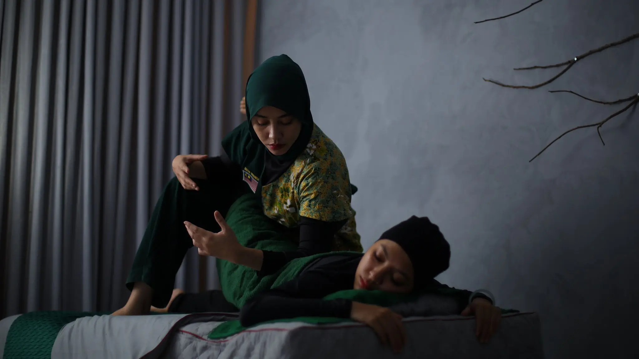 Terapis wanita FIORA memberi urutan regangan kepada pelanggan di bilik rawatan persendirian di Kota Bharu